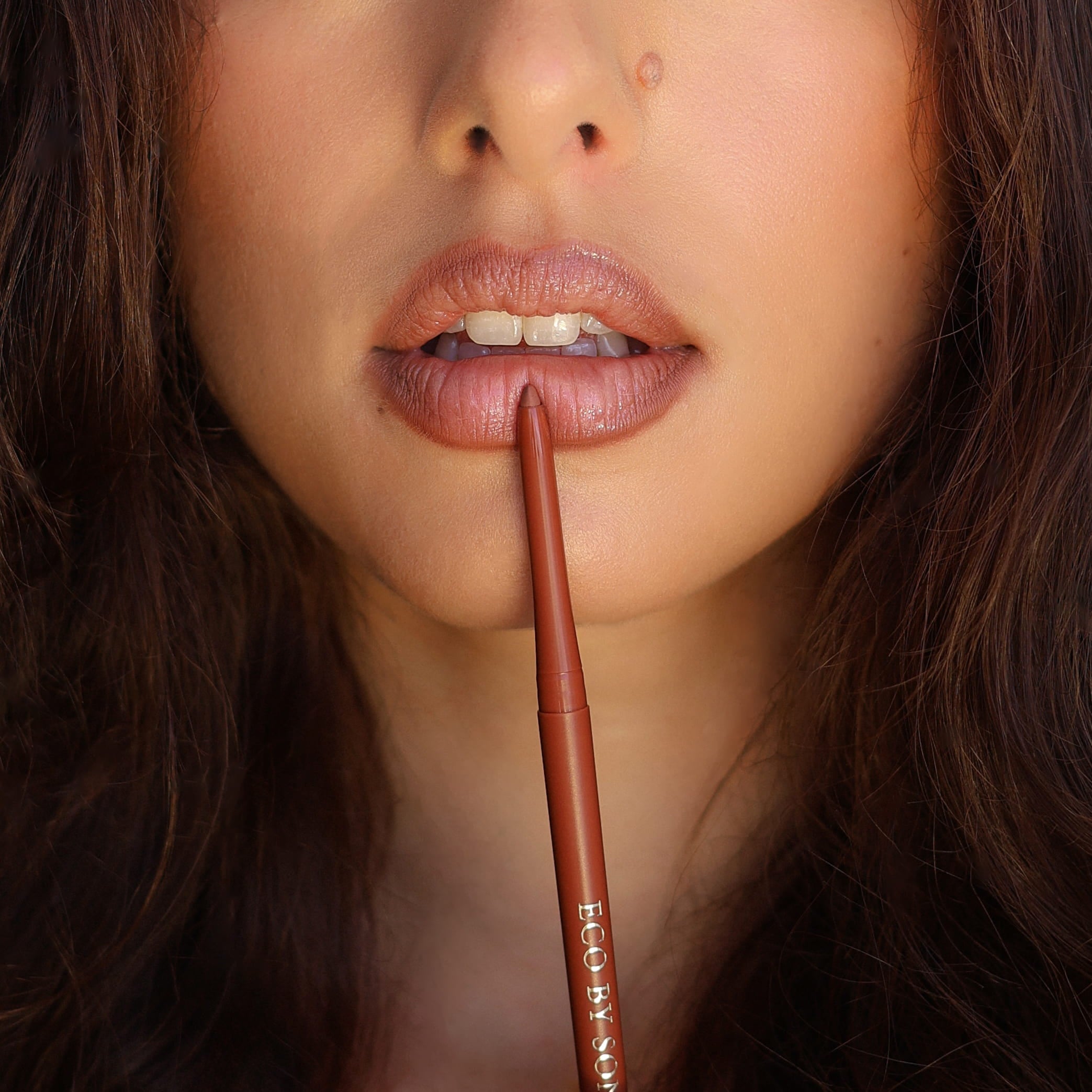 Close-up of a model’s lips holding Eco By Sonya Moody Nude lip liner against her lips.