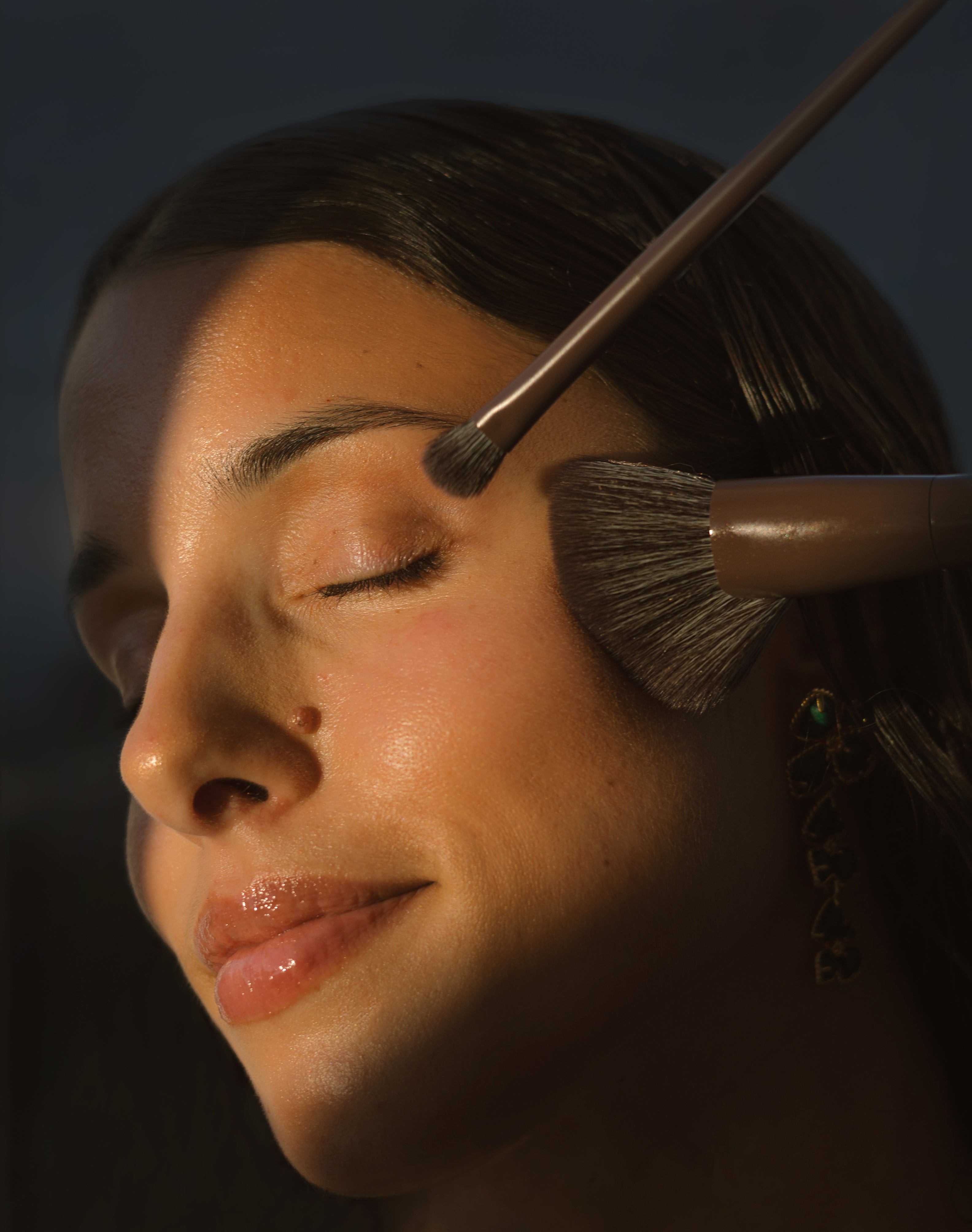 Close-up of a woman's face using 2 of the Eco By Sonya Makeup Brushes.