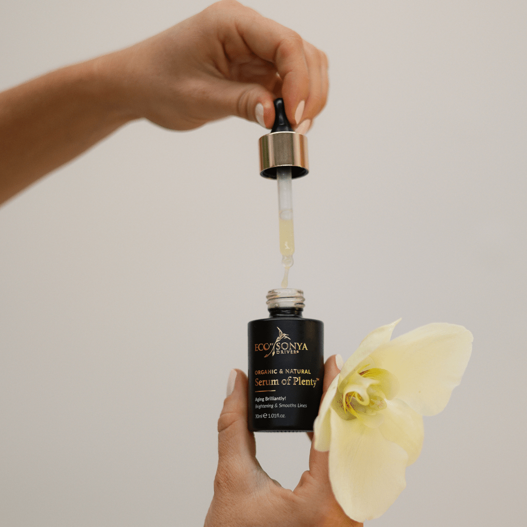 Serum of Plenty Vitamin C natural serum with hands holding dropper and yellow orchid