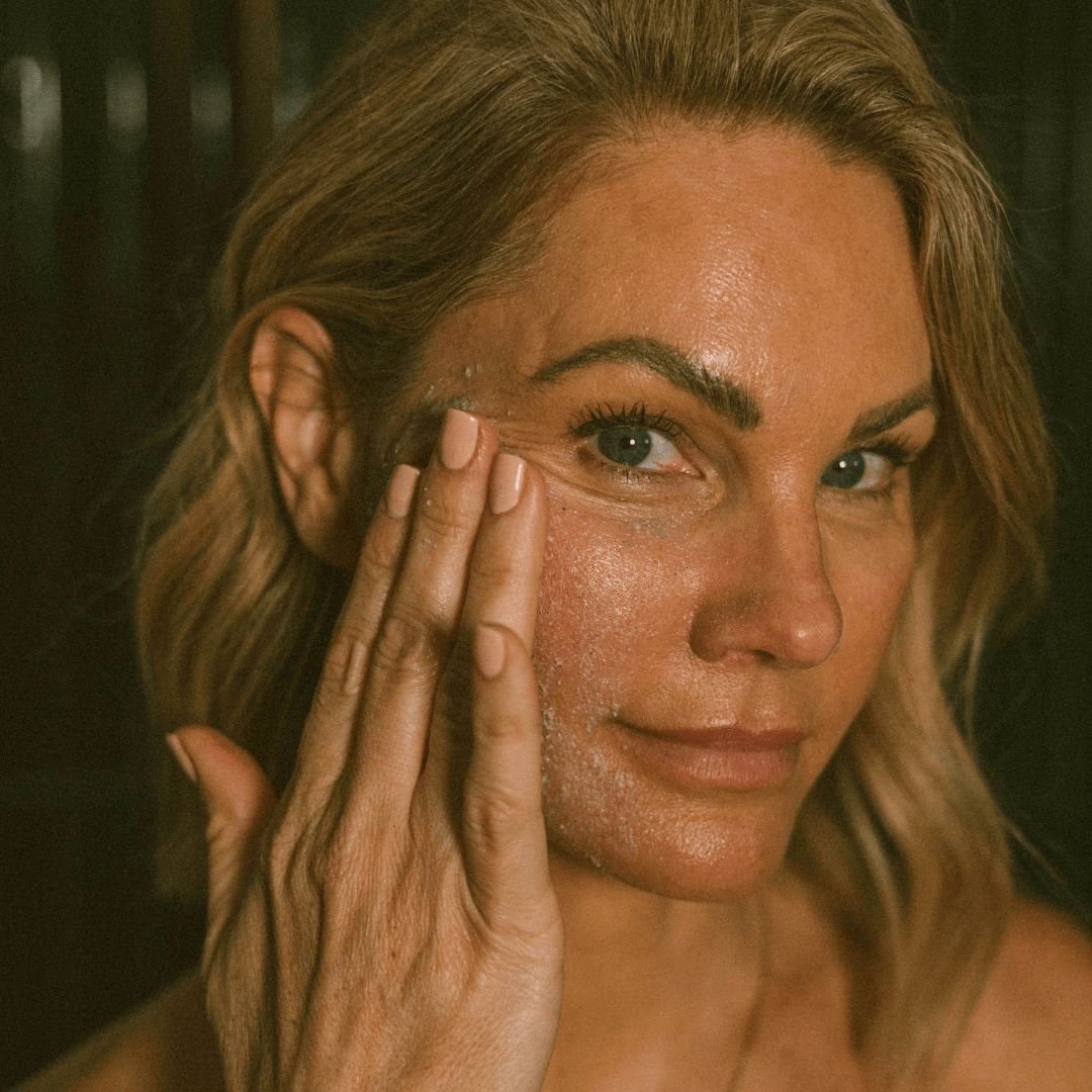 Woman applying Eco by Sonya Super Acai Exfoliator to face skin