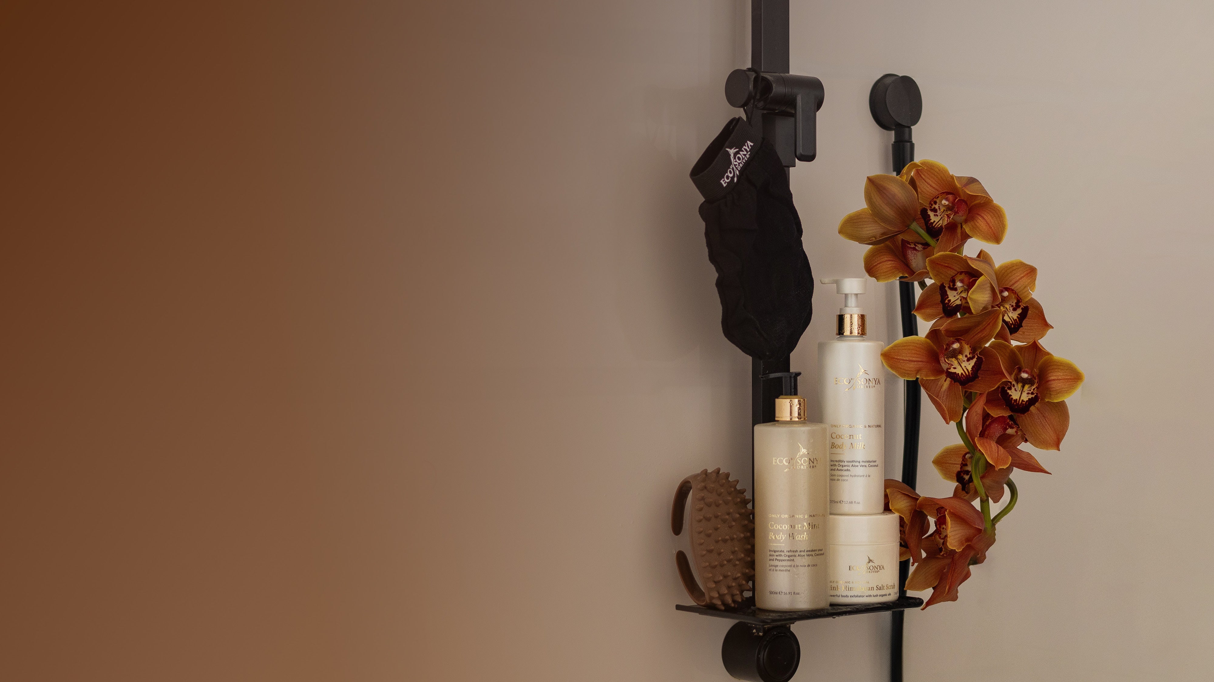 Bathroom shelf with Eco By Sonya Smooth Body Kit products and a decorative orchid on a neutral background